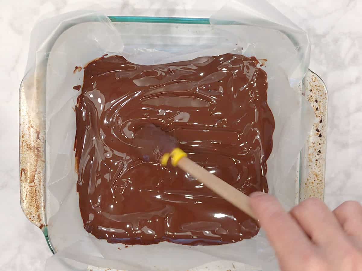 Spreading melted chocolate in the pan.