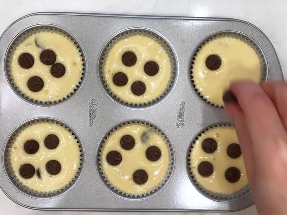 Topping the muffins with chocolate chips.