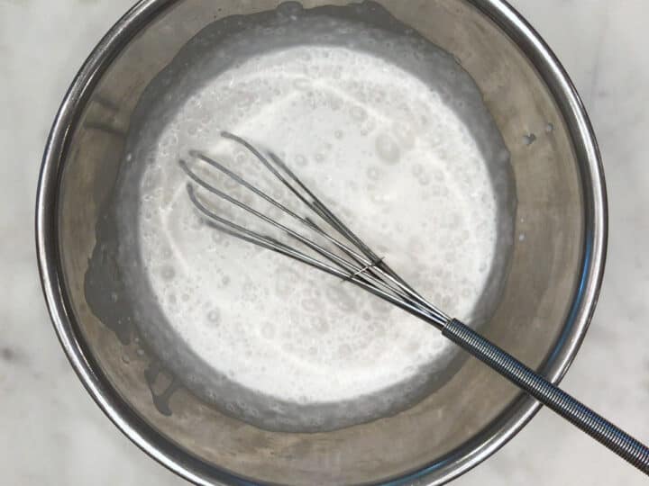 Whisking coconut milk in a bowl.