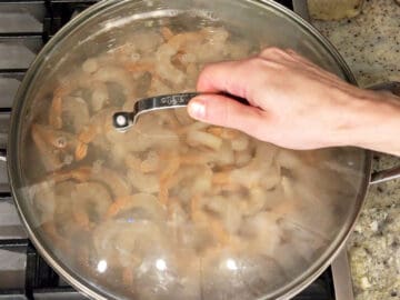 Covering the saucepan with the shrimp.