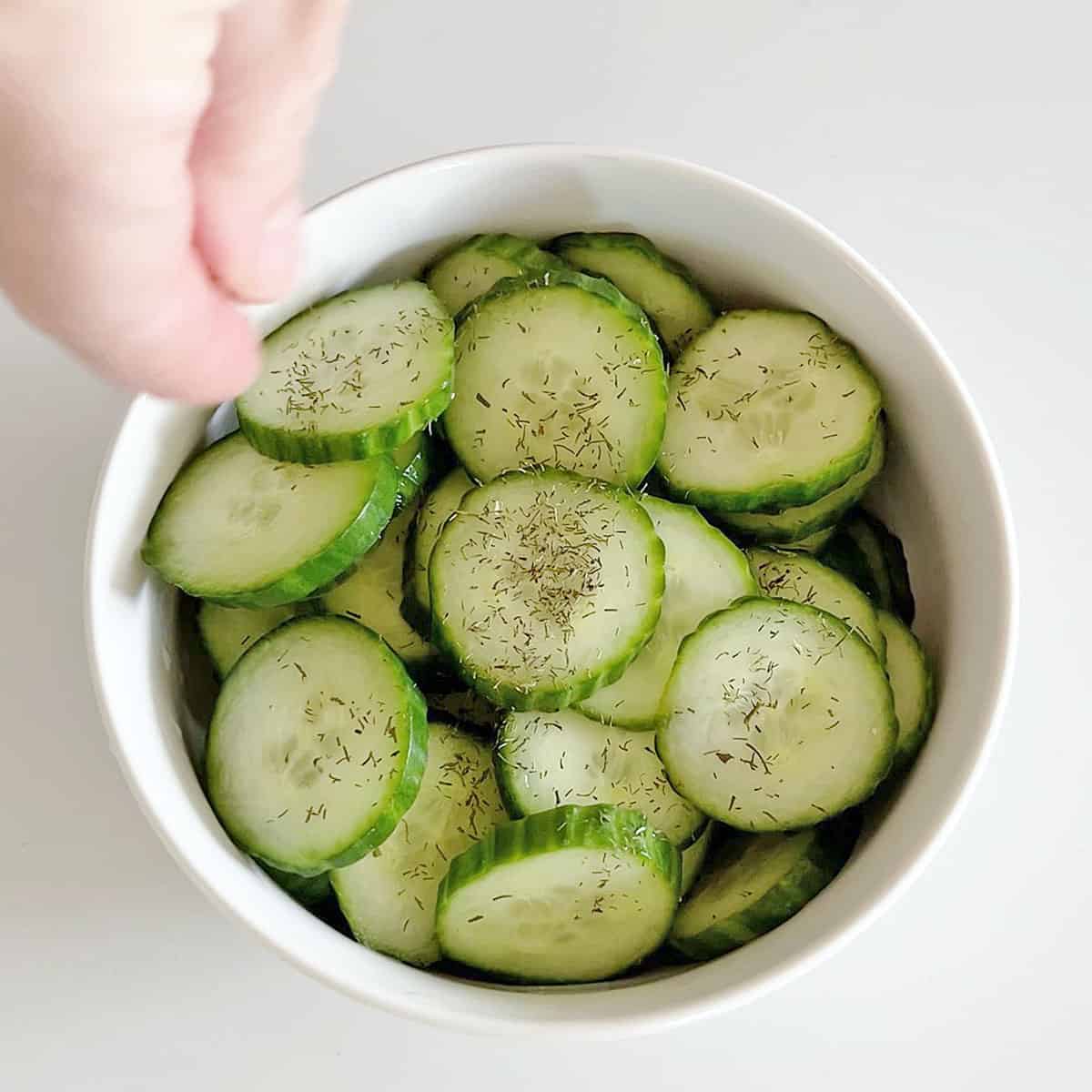 Sprinkling the salad with dill.