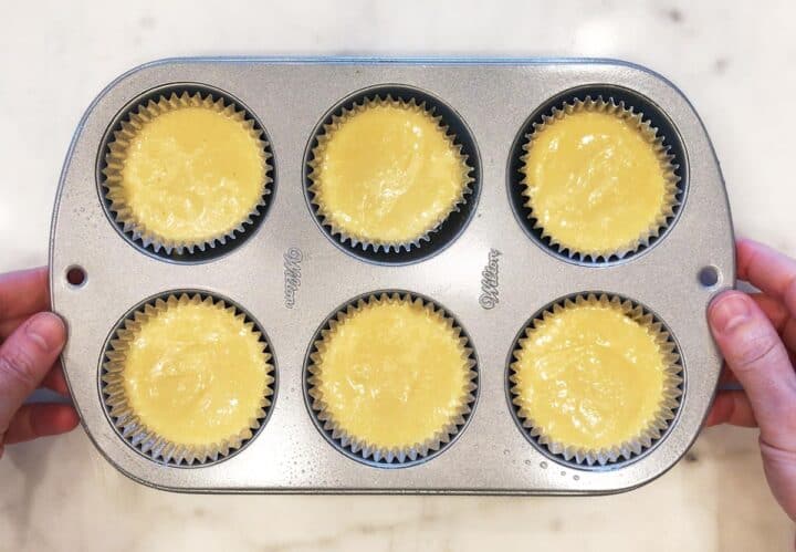 The batter has been divided between the muffin pan cavities.