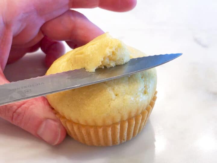 Cutting off the top of the cupcake.
