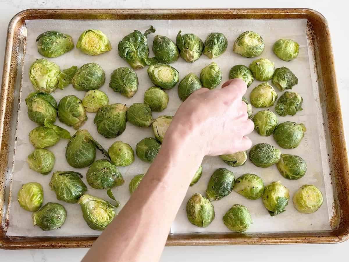 Arranging Brussels sprouts on the pan.