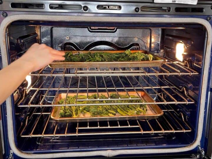 Placing the broccolini in the oven.