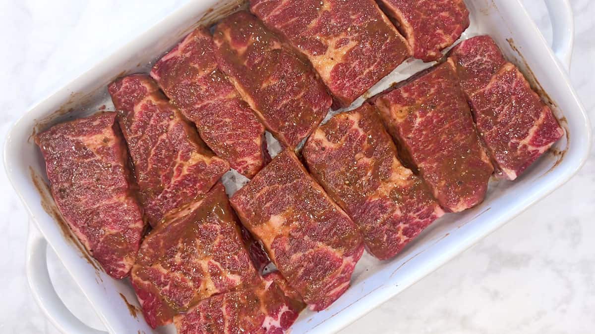 The boneless short ribs are arranged in a baking dish.