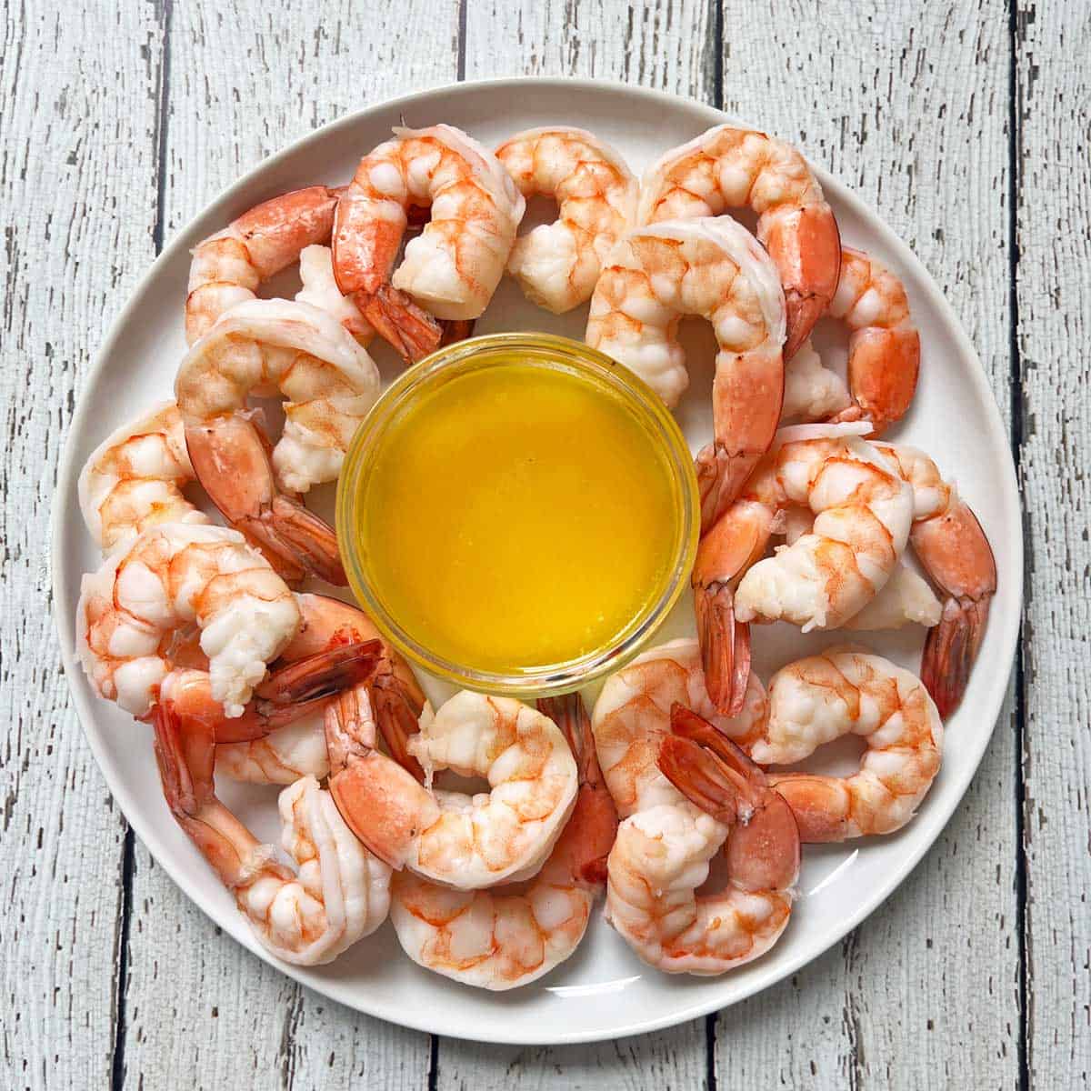 Boiled shrimp are served with melted butter.