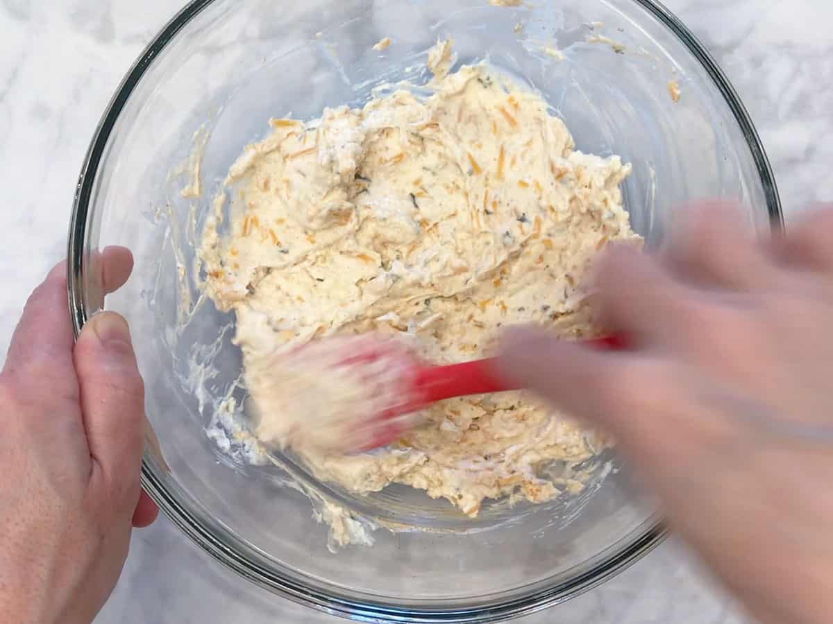 Mixing cheese ball ingredients in a bowl.