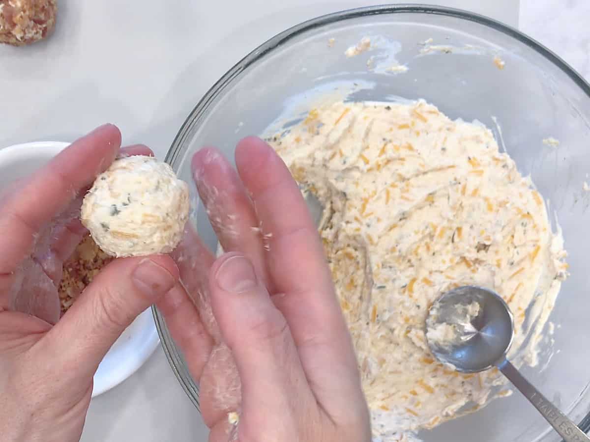 Shaping the cream cheese mixture into a cheese ball.