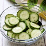 Cucumber vinegar salad is served in a glass salad bowl.