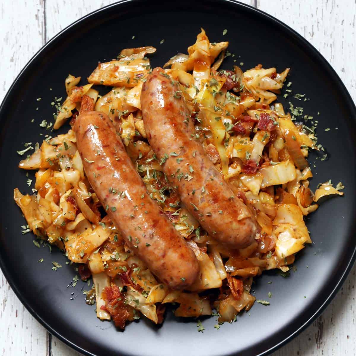 Fried cabbage is served with sausage links.