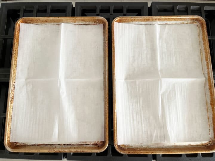Two parchment-lined, rimmed baking sheets.