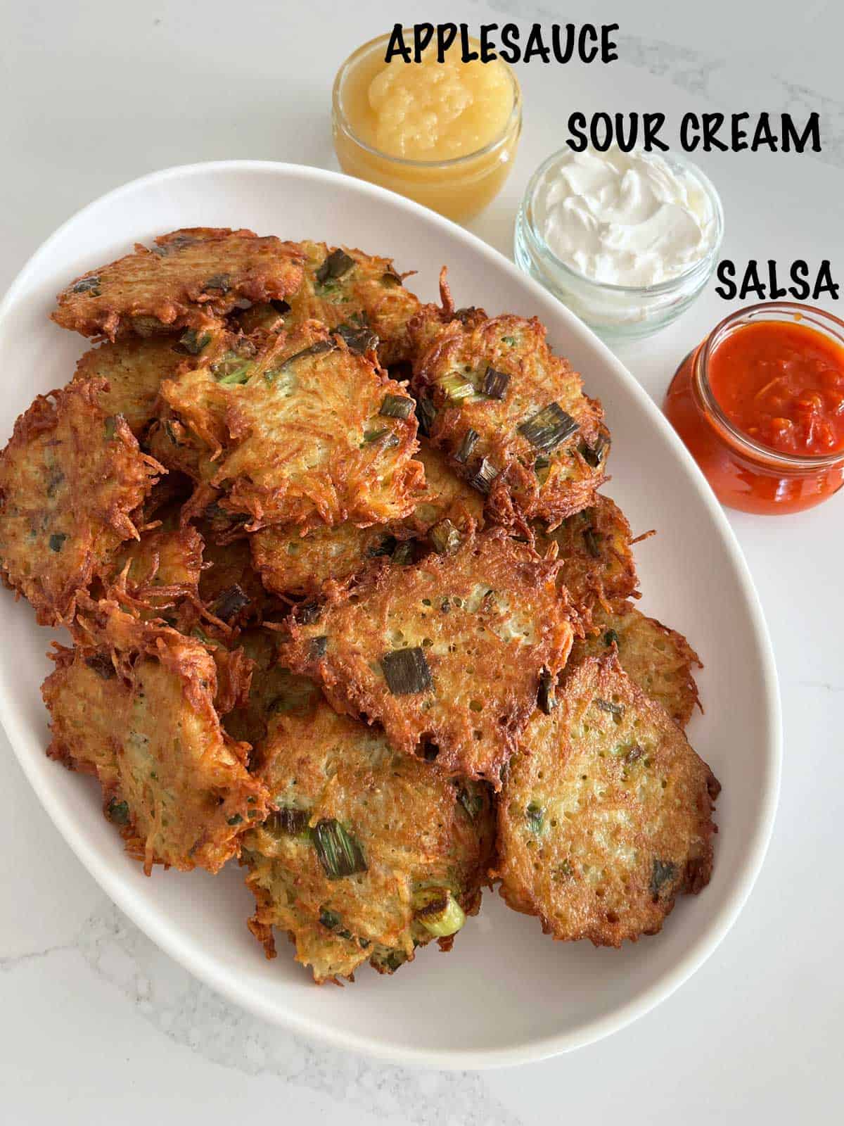 Latkes served with sour cream, applesauce, and salsa.
