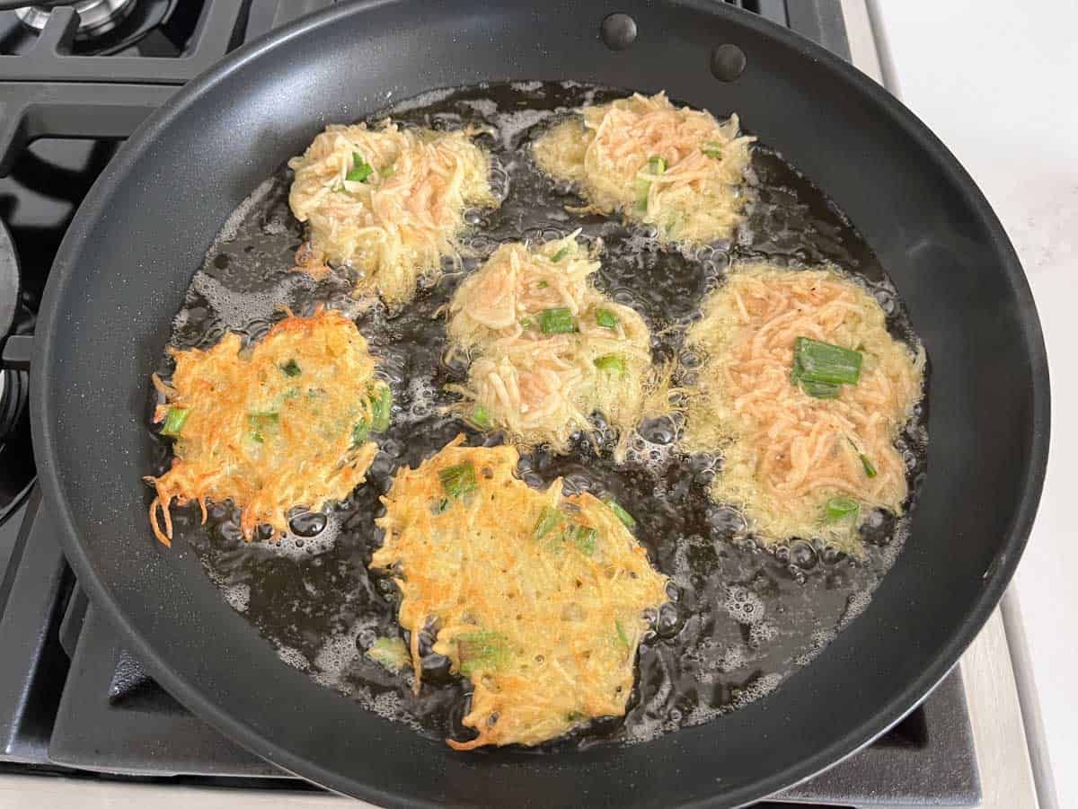 These latkes in the skillet are too light. They need to be cooked more.