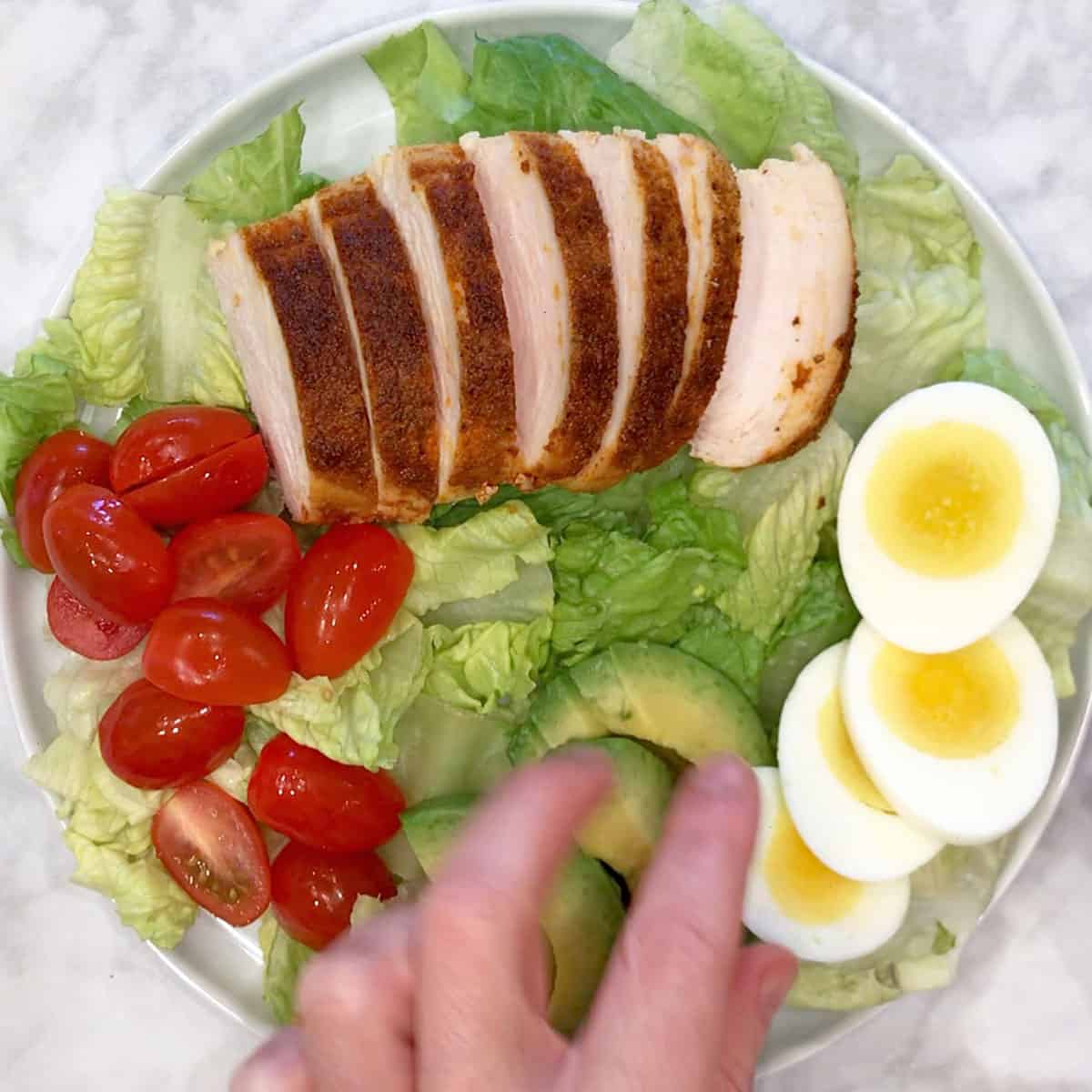Adding hard-boiled eggs to the salad.
