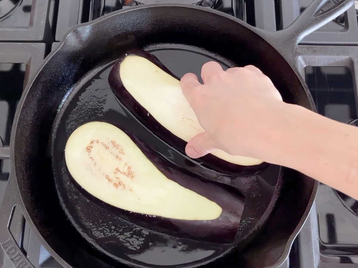 Placing the eggplant in the pan.