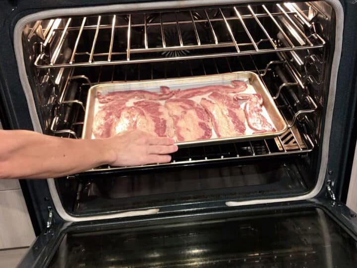 Placing beef bacon in the oven.