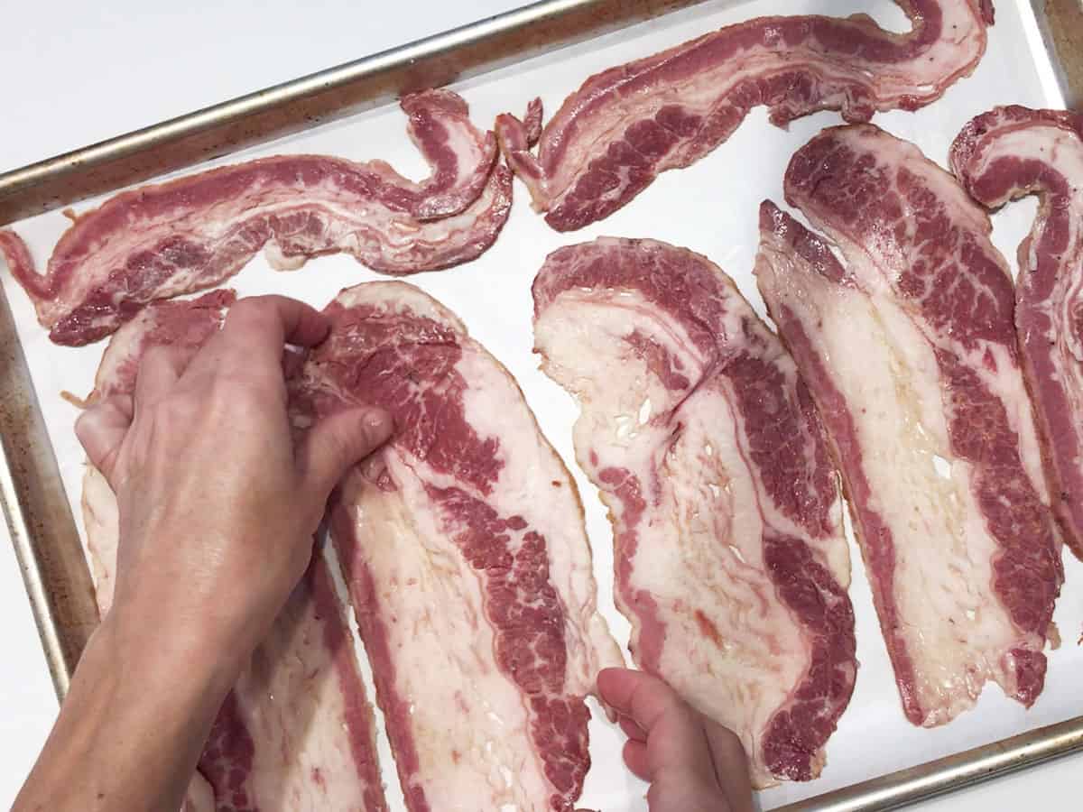 Arranging beef bacon in the pan.