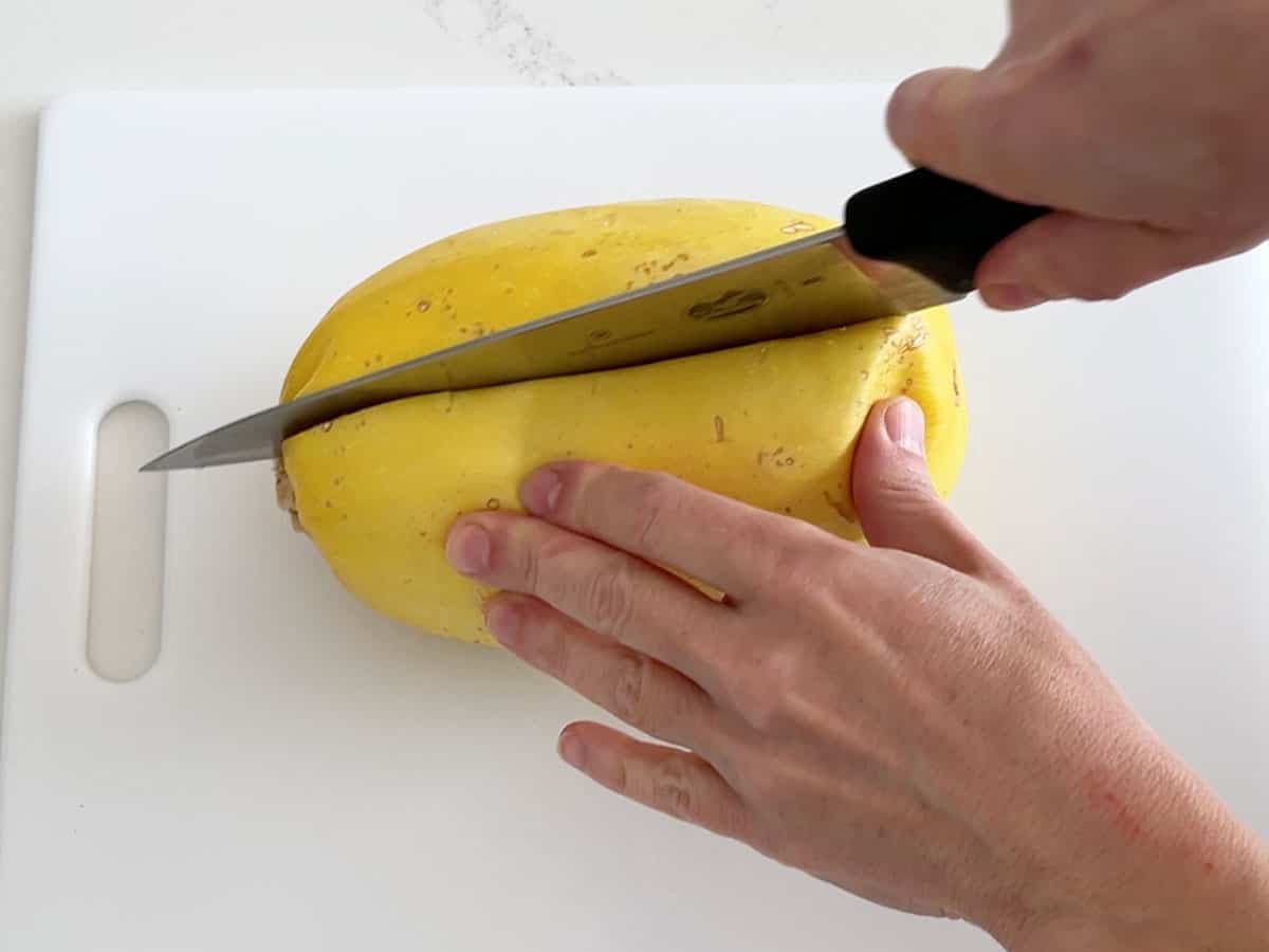 Cutting the spaghetti squash with a sharp knife.