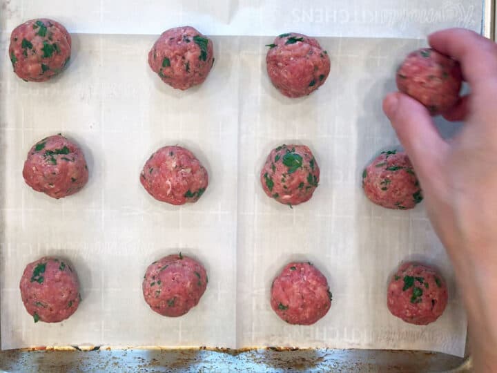 Arranging the meatballs on the baking sheet.