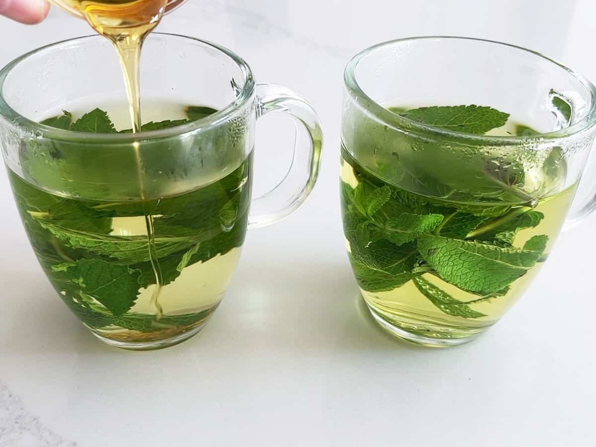 Adding honey to mint tea.