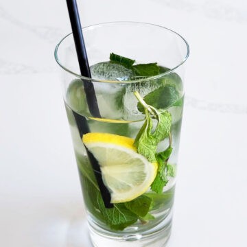 Iced mint tea is served with a drinking straw.