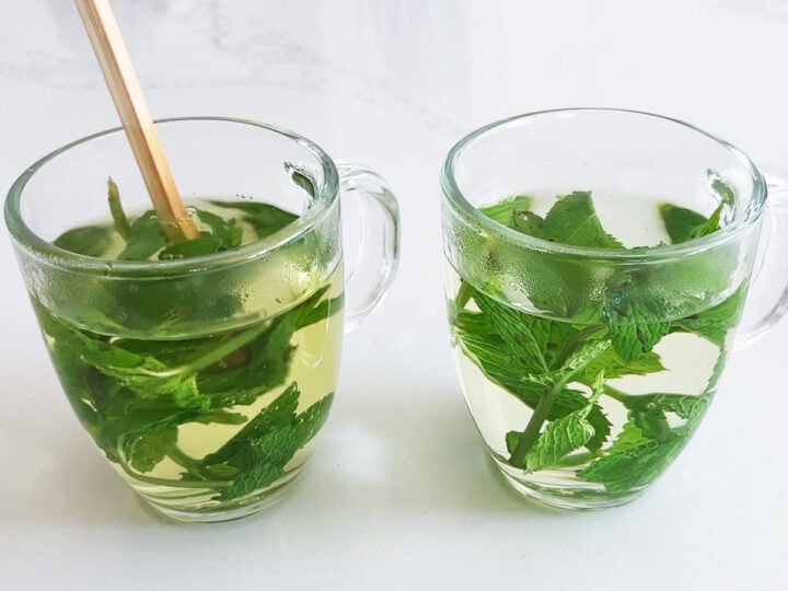 Pushing the mint leaves into the hot water.