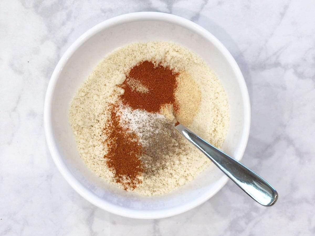 Mixing almond flour and spices in a bowl.