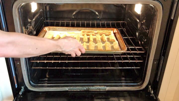 Placing the zucchini fries in the oven.