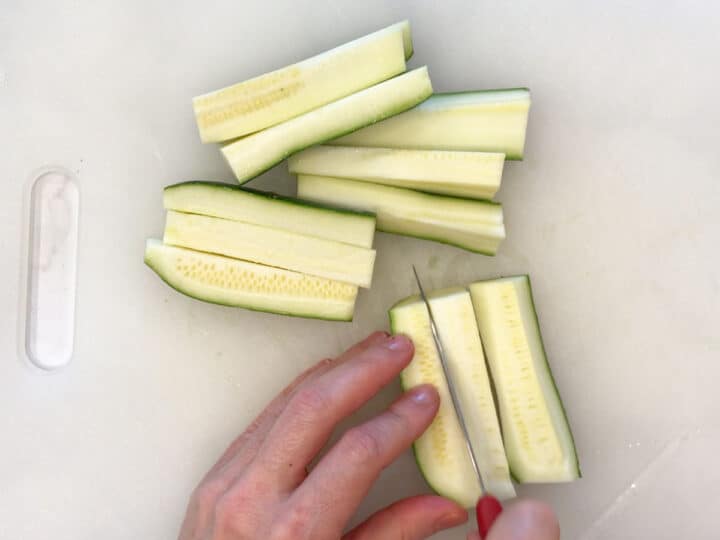 Slicing a zucchini into strips.