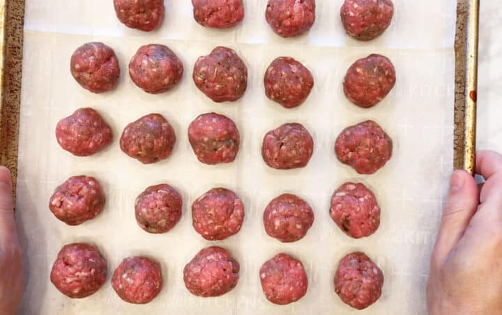 Arranging the meatballs on a baking sheet.