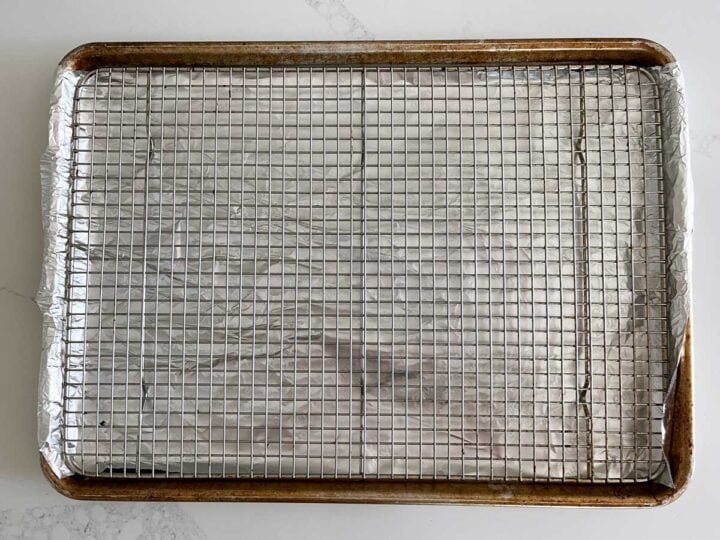 A baking sheet lined with foil and fitted with a wire rack.