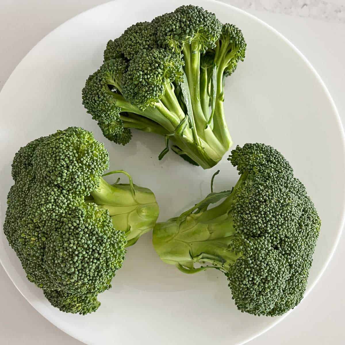 Broccoli crowns on a plate.