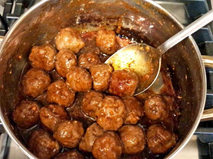 Coating the meatballs in the glaze.