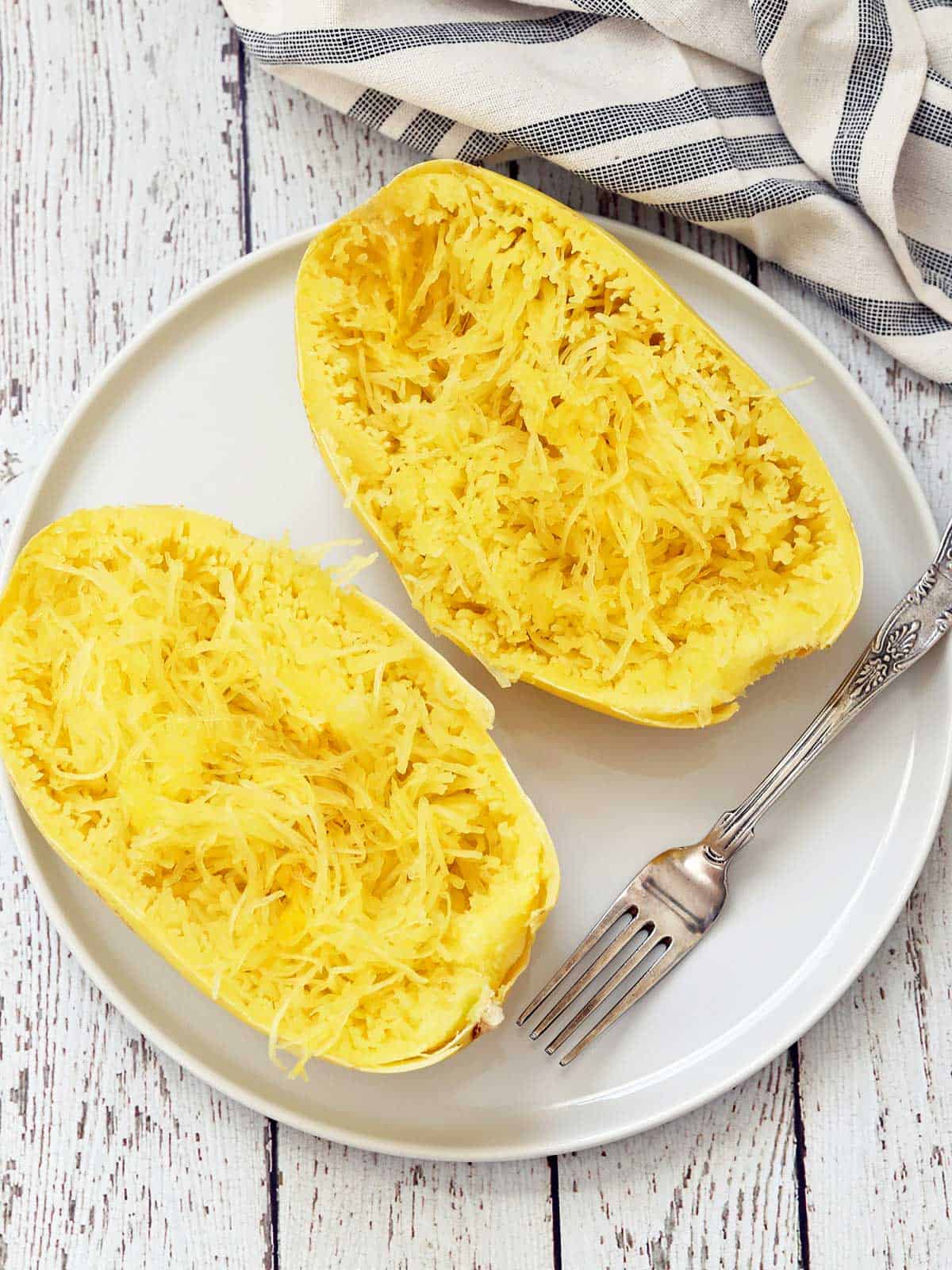 Microwave spaghetti squash is served on a plate with a fork.