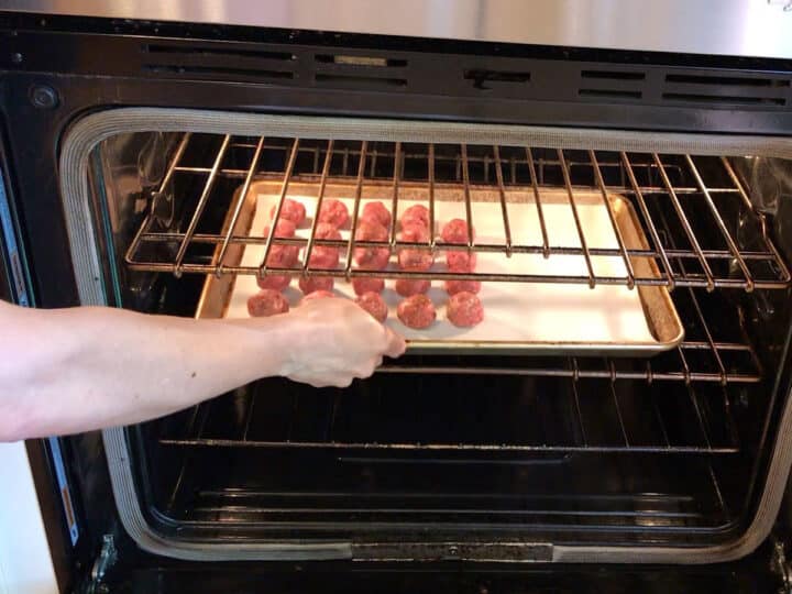 Placing Asian meatballs in the oven.