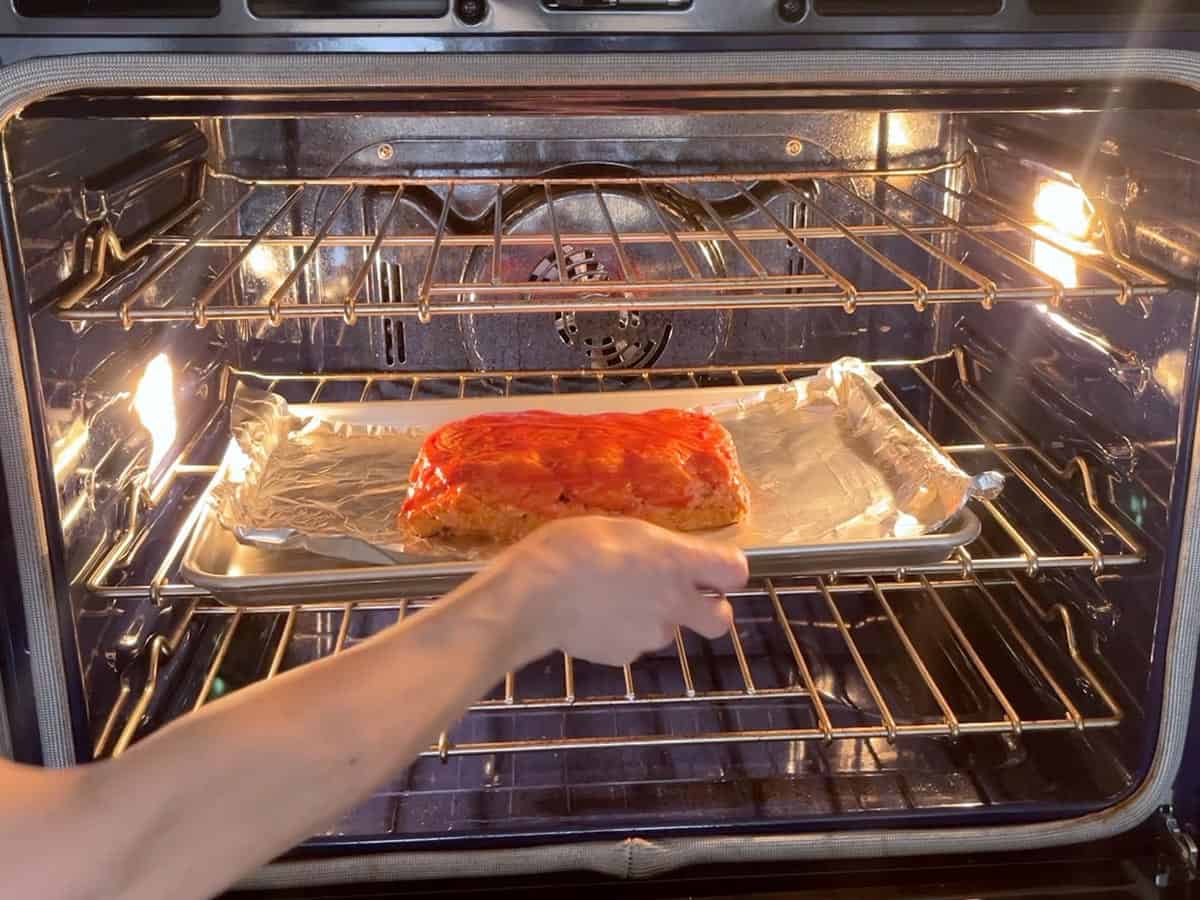 Placing the meatloaf in the oven.