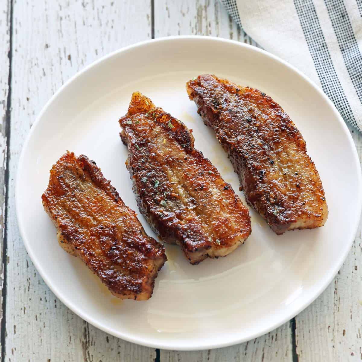 Pork belly strips are served as an appetizer.