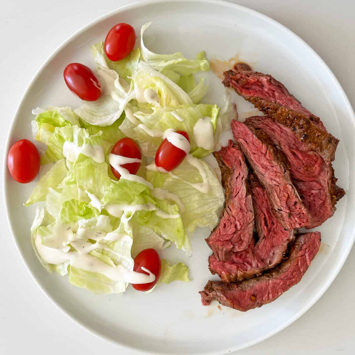 Skirt steak is served with a side salad.