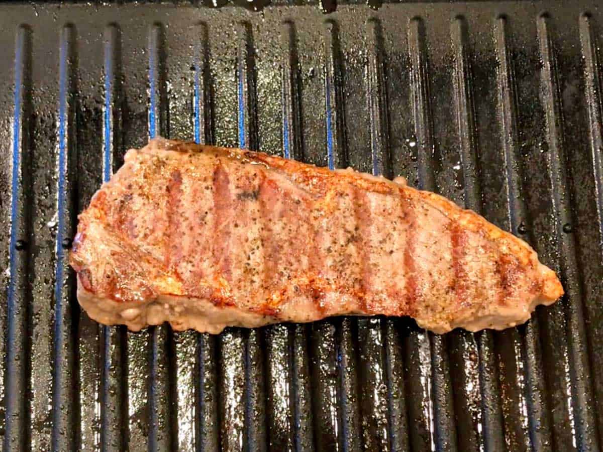 The steak is ready on the grill.