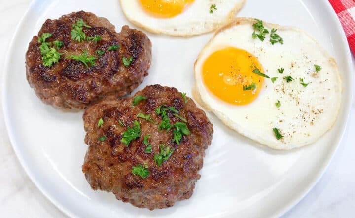 Beef sausage is served with fried eggs.