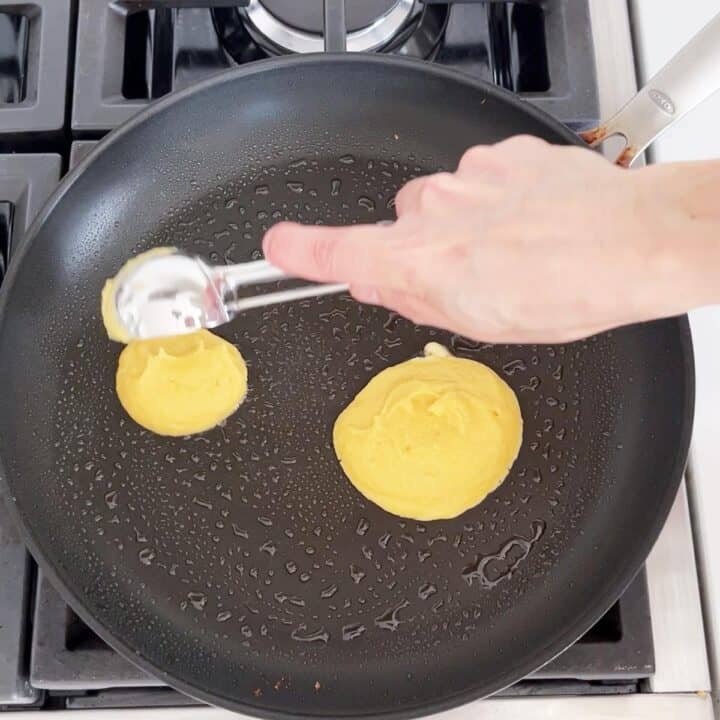 Adding the pancakes to the skillet.