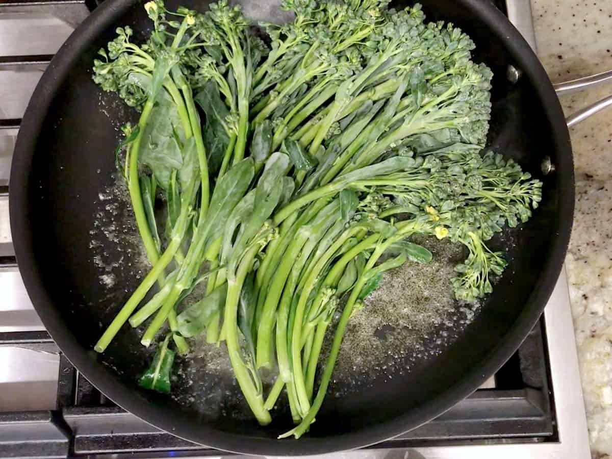 Adding the broccolini to the skillet.