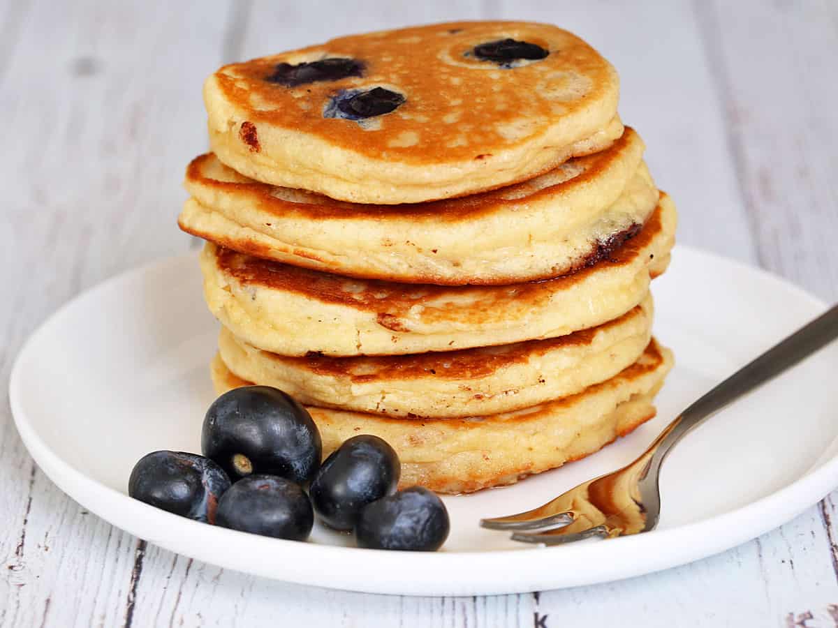 Almond flour pancakes are stacked on a plate.