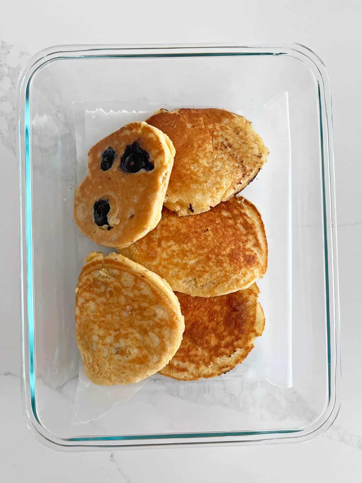 Almond flour pancakes are stored in a food storage container.
