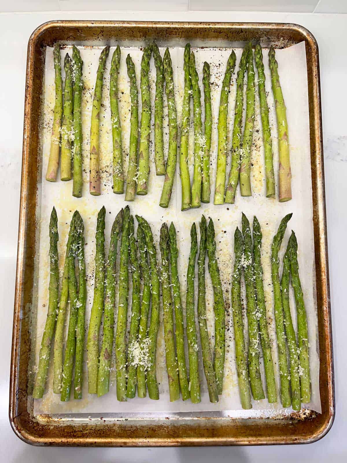 Sprinkling the asparagus with spices and parmesan.