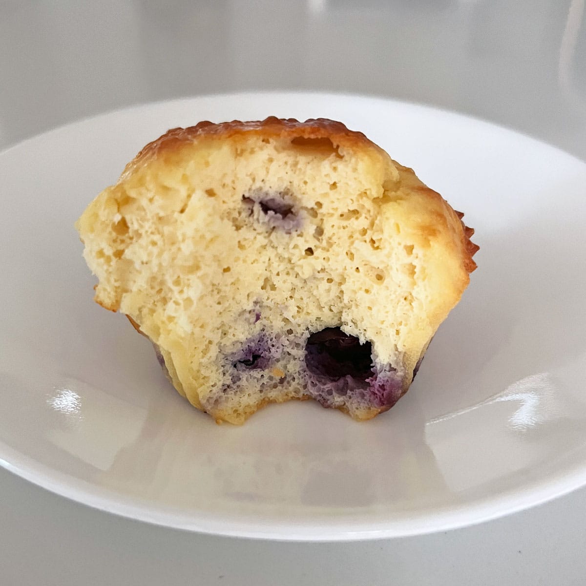 A blueberry protein muffin on a plate.