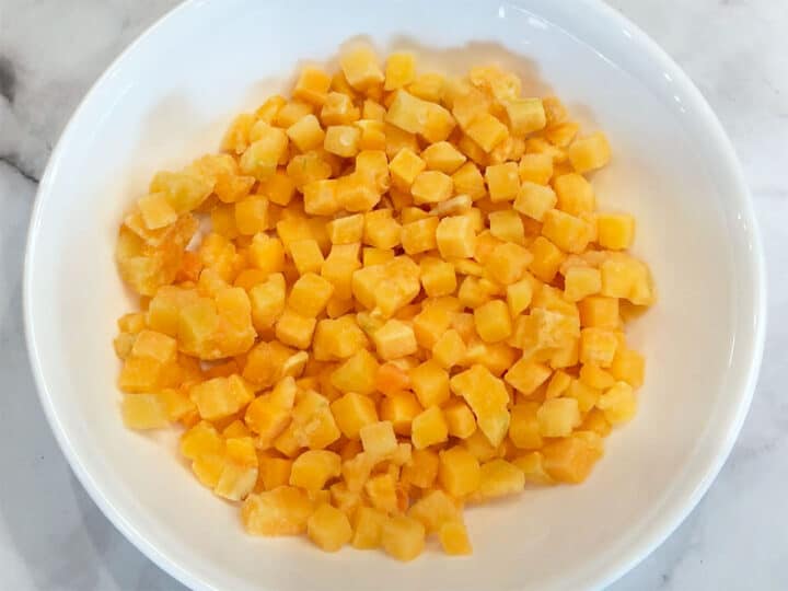 Butternut squash cubes in a microwave-safe bowl.