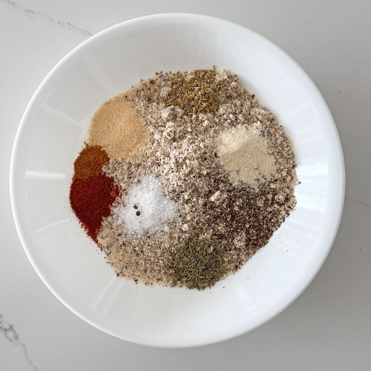 Almond meal and spices in a white bowl.