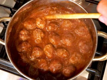 Coating the meatballs in the glaze.
